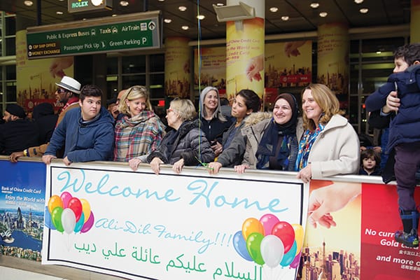 Members of Hearts and Homes for Refugees from Pelham, N.Y., help resettle refugees in their town. In photo, they wait to greet a Syrian refugee family that arrived in the United States in January.