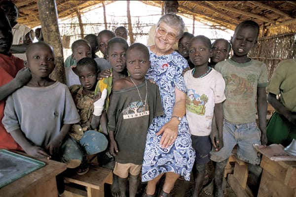 Maryknoll Sister Mary Ellen Manz smiles with students in southern Sudan. The missionary was a teacher in that African land for 25 years. (S. Sprague/S. Sudan)