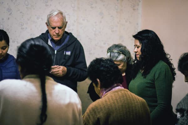 Father Paul Masson guides a small Christian community in prayer. Group members are parishioners of St. Pius X Church in Bolivia.