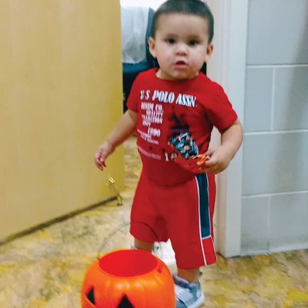 On his way to his medical checkup, 2 year-old Jesús Cantu stops to get a Halloween treat at Sister Catherine DeVito’s office who works at a Child Stress Center in Florida. (C. DeVito/U.S.)