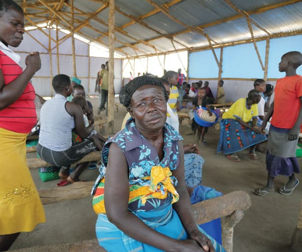 A South Sudanese woman at the refugee settlement in Uganda waits for distribution of food.