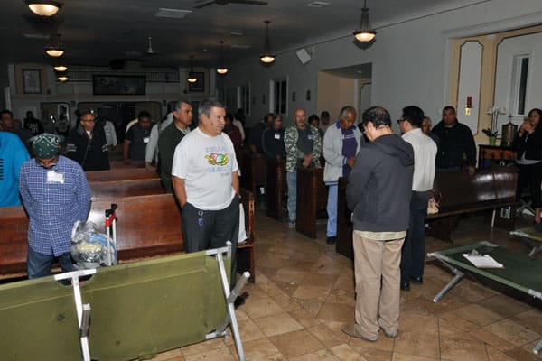 Deacon Leonel Yoque guides the group of 45 homeless people in California in a prayer and blesses