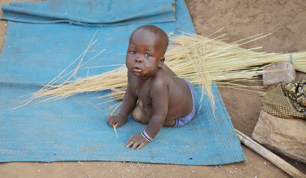 A child sits on a plastic mat at the Palabek Refugee Settlement in northern Uganda a refuge from South Sudan have fled.