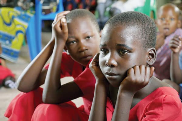 Two girls attend Mass said by Father Schoellmann at an outstation chapel in Mwamanimba, Tanzania. Father Schoellmann also ministers to nomadic tribes such as the Watatulu people who live in the area.