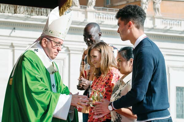 Listening, Discerning, Engaging Youth and Young Adults: Pope Francis accepts the offertory gifts from young people at the opening Mass of the Synod of Bishops last October in St. Peter's Square. (CNS/Vatican Media/Rome)