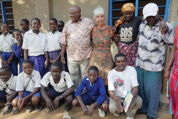Sister Hughes is surrounded by students she helps outside of Musoma, Tanzania.