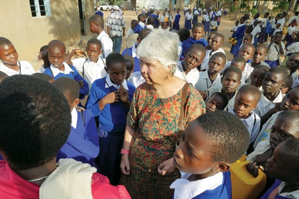 Sister Hughes is surrounded by students she helps outside of Musoma, Tanzania.