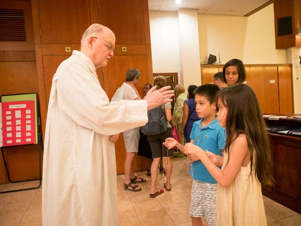 Father Cuff blesses children's rosaries after Saturday Mass at St. Anne Parish in Stanley, Hong Kong. (N. Sprague/Hong Kong)