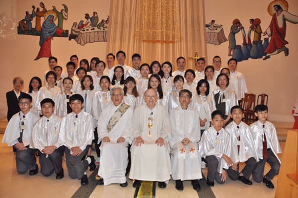 Evangelizing among skyscrapers - Father Cuff smiles with parishioners at Our Lady of Mount Carmel parish in Hong Kong.