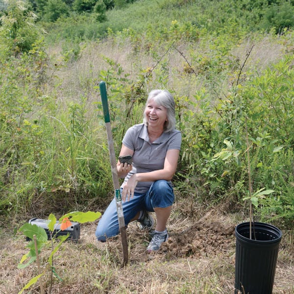 During an Appalachia immersion trip, participant Theresa Johnson plants a blight-resistant American chestnut tree as a step toward restoring land in Robinson Forest in eastern Kentucky. Photo by O. Duran/U.S.