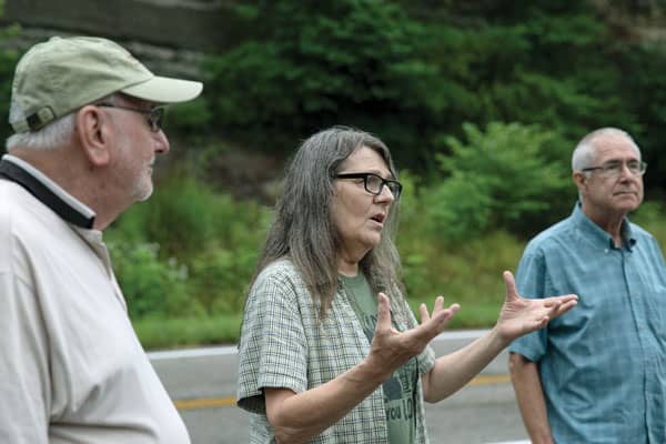 Elaine Tanner tells of her efforts to bring mining companies to court to clean up toxic waste that contaminates water, turning it orange. Tanner, flanked by Glenmary Father John Rausch, left, and Deacon Paul Bork, spoke to participants of an Appalachia immersion trip in Deane, Kentucky. Photo by O. Duran/U.S.