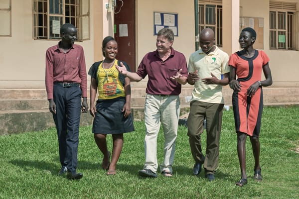 Maryknoll Lay Missioner Gabe Hurrish (c.) walks with students in Solidarity Teacher Training College, where he helps prepare future educators. (P. Jeffrey/S. Sudan)