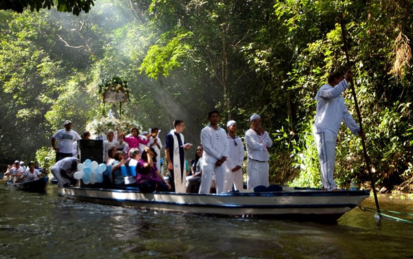 Amazonian faces of the Church: A priest holds a Bible as he leads pilgrims in prayer along during an annual river procession and pilgrimage on the Caraparu River in Santa Izabel do Para, Brazil, in this 2012 file photo. (CNS, P. Santos, Reuters/Brazil)