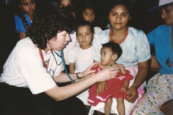 A young Dr. Carr gave medical care to children in the village of Gimilile when she was part of a U.S. parish delegation visiting El Salvador in 1998. (Courtesy of A. Carr/El Salvador)