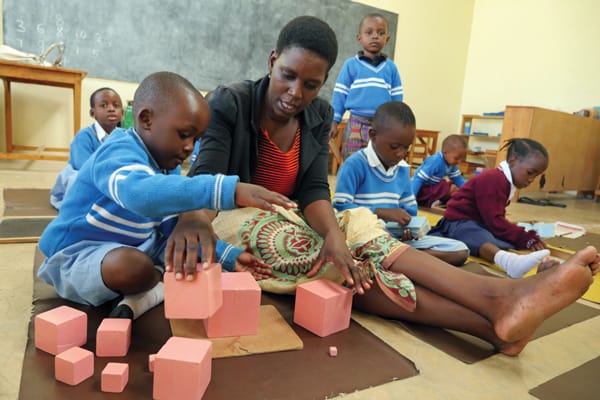 Teacher Anna John helps students develop coordination and motor skills in a preprimary class at Mercy Montessori School in the Ilemela section of Mwanza. The school, founded by Maryknoll Sister Celeste Derr, focuses on education with a compassionate touch.Photo by Sean Sprague/Tanzania)