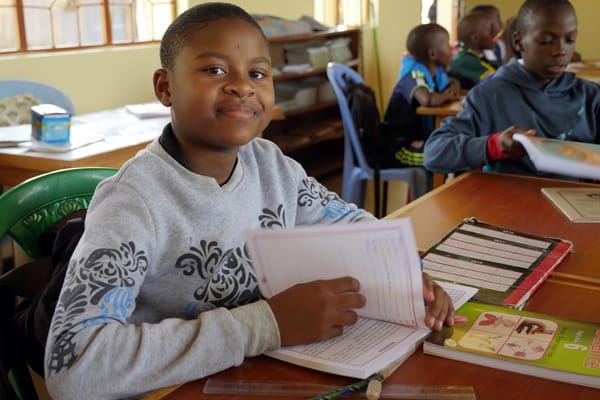 A student at Mercy Montessori School in the Igombe section of Mwanza, Tanzania, looks up from her studies. The school was founded by Maryknoll Sister Celeste Derr. Photo by Sean Sprague/Tanzania