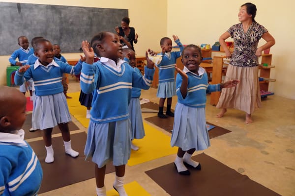 Guadalupe Petro, right, a Maryknoll lay missioner, leads pupils of the Mercy Montessori School in a lesson that is reinforced with song and dance. The school, founded by Sister Celeste Derr in Mwanza, Tanzania, emphasizes education with a gentle and compassionate touch. Photo by Sean Sprague/Tanzania.