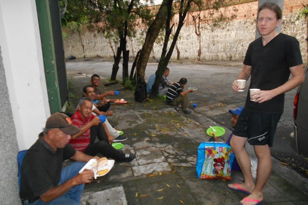 Tim Ross serves coffee to homeless men outside the La Carpa Catholic Worker hospitality house in San Salvador’s Barrio San Miguelito. (Erica Olson/El Salvador)