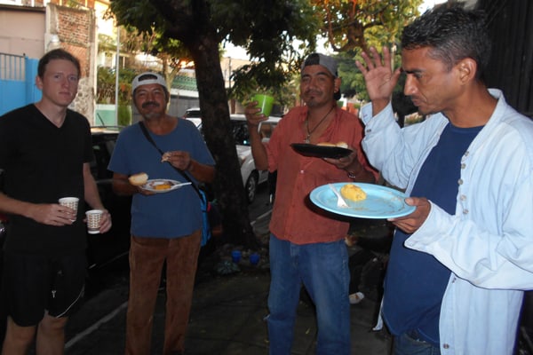 Maryknoll Lay Missioner Tim Ross (left) shares a moment with homeless men outside the La Carpa Catholic Worker hospitality house in San Salvador. (Erica Olson/El Salvador)