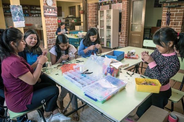 Myrna Arébalo (second from left) teaches the girls to make costume jewelry, which they will sell along with baked goods to raise funds for Hogar Nuestra Casa shelter. (Nile Sprague/Bolivia)