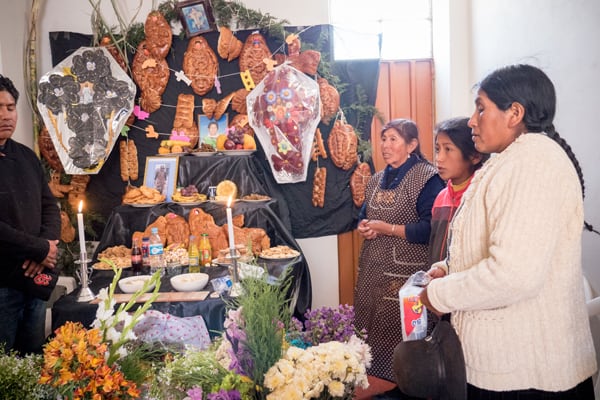 Visitors and Aymara residents of Jayllihuaya, including Father Cookson, gather at the house of the Flores family to pray for their deceased relatives and honor their memory. (N. Sprague/Peru)