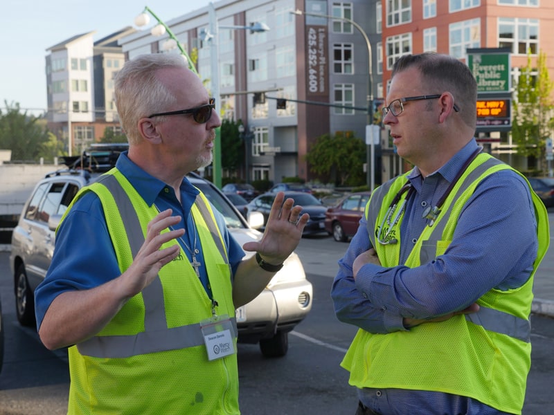 Deacon Dennis Kelly, left, a Maryknoll deacon partner, discusses the work of MercyWatch to help the homeless with fellow volunteer Dr. Jimmy Grierson, a family medical physician. (Peter Saunders/U.S.)