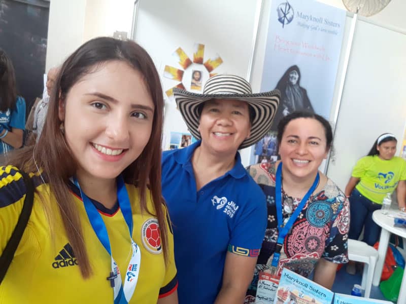Maryknoll Sisters Nena Heramil (center) and Norma Pocasangre (right) smile with a World Youth Day pilgrim who visited their vocation booth. (Courtesy of the Maryknoll Sisters/Panama)