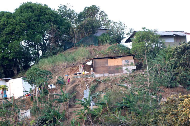 Dwellings like this, made of wood and damaged by the rain, were able to be replaced by concrete one-room homes through a project of the social action team of Vianney parish.