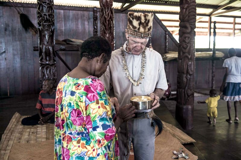 Maryknoll Father Vincent Cole gives Holy Communion to Sabina Totiniap, an Asmat indigenous woman who helps him. Photo by Joshua Irwandi/Indonesia