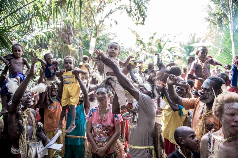 The Asmat people of Sa and Er villages lift their newly baptized children at the end of the jungle baptism ceremony. Photo by Joshua Irwandi/Indonesia