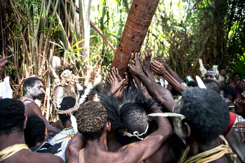 Following a baptism in the jungle of West Papua, Indonesia,, Asmat people erect a wooden pole with the names of the newly baptized children. Photo by Joshua Irwandi/Indonesia