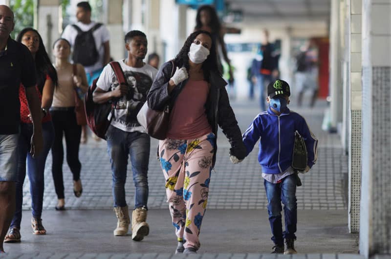 Latin American governments weigh pandemic shutdown vs. economic hardship: A woman and child wearing protective masks walk through Central do Brasil train station in Rio de Janeiro during the coronavirus pandemic March 24, 2020. (CNS photo/Ricardo Moraes, Reuters)