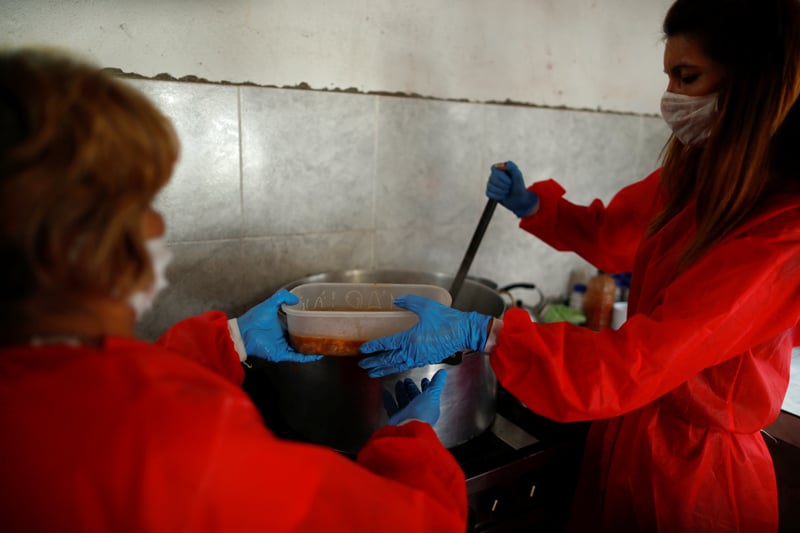 Volunteers wearing protective masks serve stew at a soup kitchen in Buenos Aires, Argentina, March 26, 2020. (CNS photo/Agustin Marcarian, Reuters)
