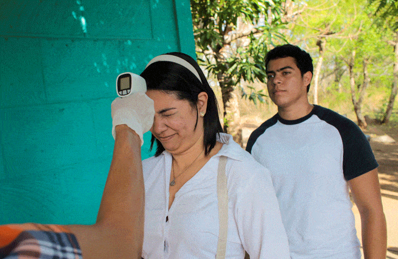 Nicaraguan officials stop church program to prevent COVID-19: A woman reacts as her temperature is checked at the entrance of American University in Managua, Nicaragua, March 19, 2020, during the coronavirus pandemic. (CNS photo/Oswaldo Rivas, Reuters)