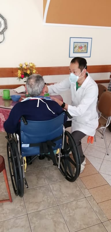 Matthew Sim, a Maryknoll seminarian from Singapore, feeds a resident at a senior home in Cochabamba, Bolivia.