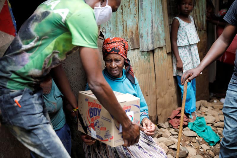 COVID-19 Impacts East Africa: An elderly woman receives a box of food donations given by an aid group to people in need in a poor section of Nairobi, Kenya, April 14, 2020, during the coronavirus pandemic. U.S.-based aid groups are providing funding and other support to communities most vulnerable to COVID-19 around globe. (CNS photo/Baz Ratner, Reuters)