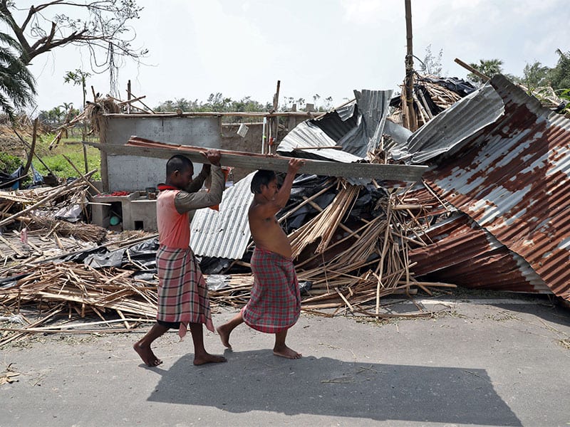 Residents carry tin sheets salvaged from the rubble of a damaged house in a village near Kolkata, India, May 22, 2020, in the aftermath of Cyclone Amphan. (CNS photo/Rupak De Chowdhuri, Reuters