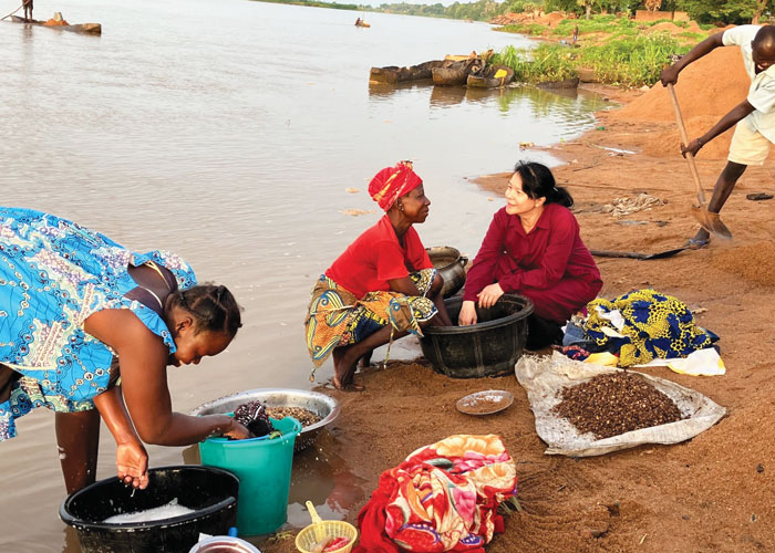 Maryknoll Sister NgocHà Pham (right) visits Logone River where local people fish, wash clothes, prepare food and collect gravel for brickmaking. (Courtesy of NgocHà Pham/Chad)