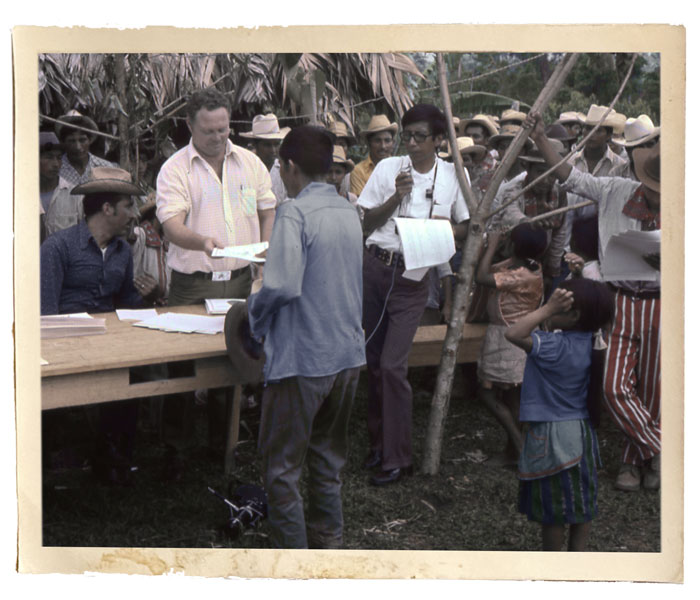 Maryknoll Father William Woods distributes deeds for land in the Ixcán jungle where he helped 2,000 families settle. The photographer of this photo was killed with John Gauker and Father Woods in the plane crash. (Selwyn Puig/Maryknoll Mission Archives/Guatemala)