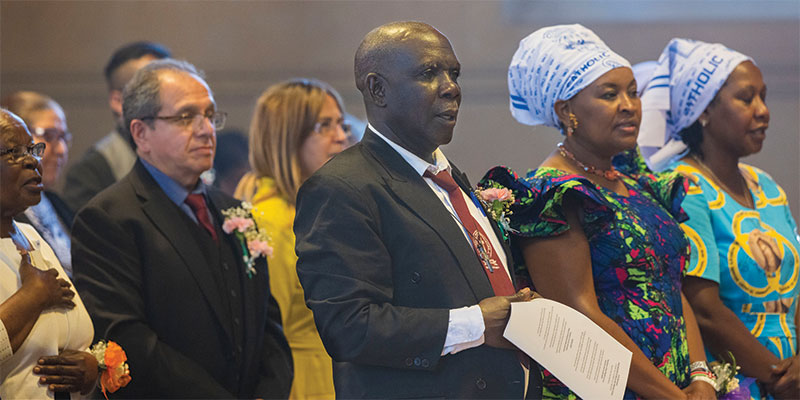 Father Maondo’s father, Nicholas, beamed with pride during the ceremony. The older Maondo was able to travel from Kenya. His wife, however, was denied a visa to the United States. “We have been accompanying and supporting Joshua for a long time,” the senior Maondo said. “It’s been a long journey, but he did it.”</p>
<p>Father Maondo’s aunt, Sister Terry Makokha of the Sisters of St. Joseph of Mombasa, who is studying and serving in Pennsylvania, said she was happy that her young nephew is following “this special calling.” She conveyed her wishes: “I pray that he may continue answering God’s call.”</p>
<p>Sadly, Father Ogony’s parents were denied U.S. visas to attend the ordination. To represent his family, the ordinand chose Alfredo and Verónica Vega, a parishioner couple from the Mother of the Americas Church in Chicago where he volunteered during his formation. The couple, originally from Mexico, was the first to welcome Father Ogony to the parish when they mistakenly thought he did not speak Spanish. “Carlitos,” as they fondly call Father Ogony, became a source of strength for the Vega family through hard times.