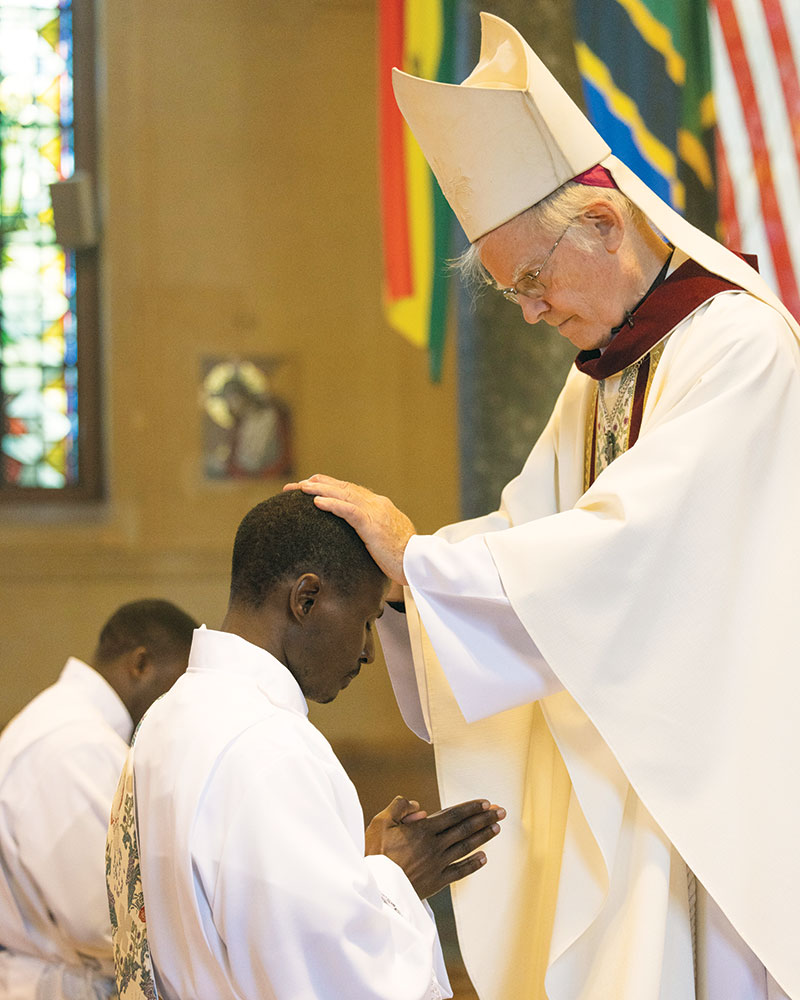 Auxiliary Bishop of New York Peter Byrne, the ordaining bishop, lays hands upon the two Maryknoll ordinands. (Octavio Durán/U.S.)