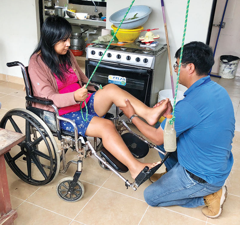 During a home visit in Entre Ríos, Willy García, a nurse with the Social Justice Foundation, teaches muscle strengthening exercises to Yeydy Olivera. (Meinrad Scherer-Emunds/Bolivia)