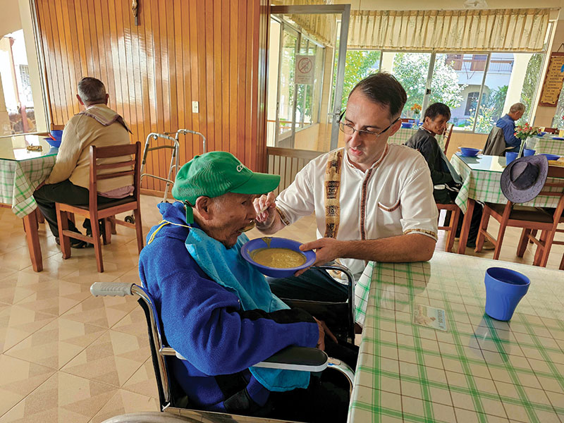 Brother Thibert feeds an elderly resident at Hogar San José. (Courtesy of Ryan Thibert/Bolivia)